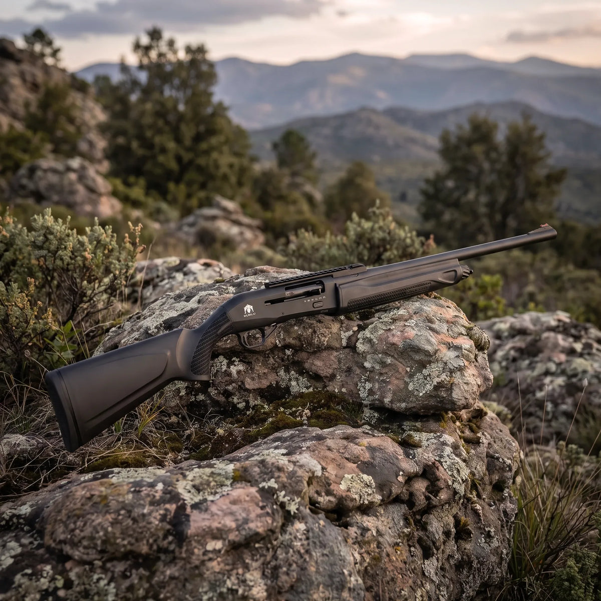 Escopeta Huglu Mod. Veyron calibre 12 apoyada en rocas durante una jornada de caza en la naturaleza. 